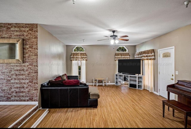 living room with ceiling fan, hardwood / wood-style floors, and a textured ceiling