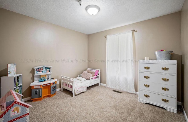 bedroom featuring carpet flooring and a textured ceiling