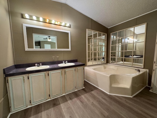 8502 Old Bagley Rd, Dora, AL 35062 - full bath with wood finished floors, a garden tub, double vanity, a textured ceiling, and vaulted ceiling