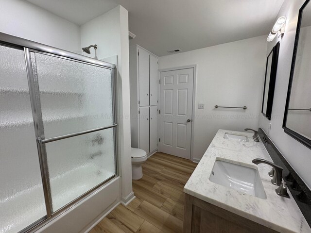 8502 Old Bagley Rd, Dora, AL 35062 - full bathroom with wood finished floors, double vanity, and enclosed tub / shower combo