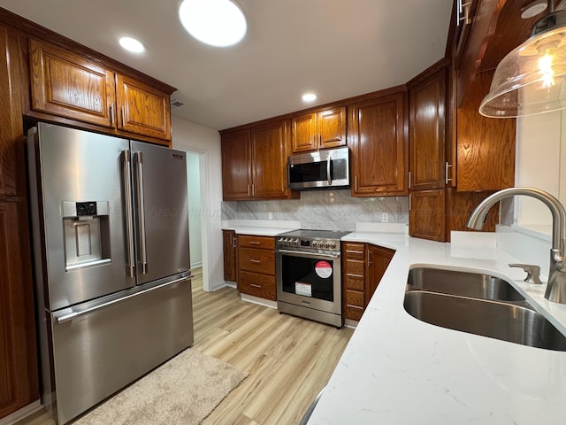 8502 Old Bagley Rd, Dora, AL 35062 - kitchen featuring high end appliances, light wood-style floors, decorative backsplash, recessed lighting, and brown cabinetry