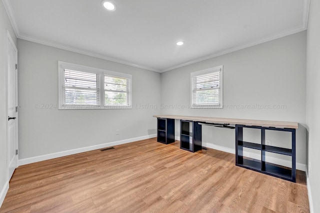 unfurnished office featuring light wood-type flooring and crown molding