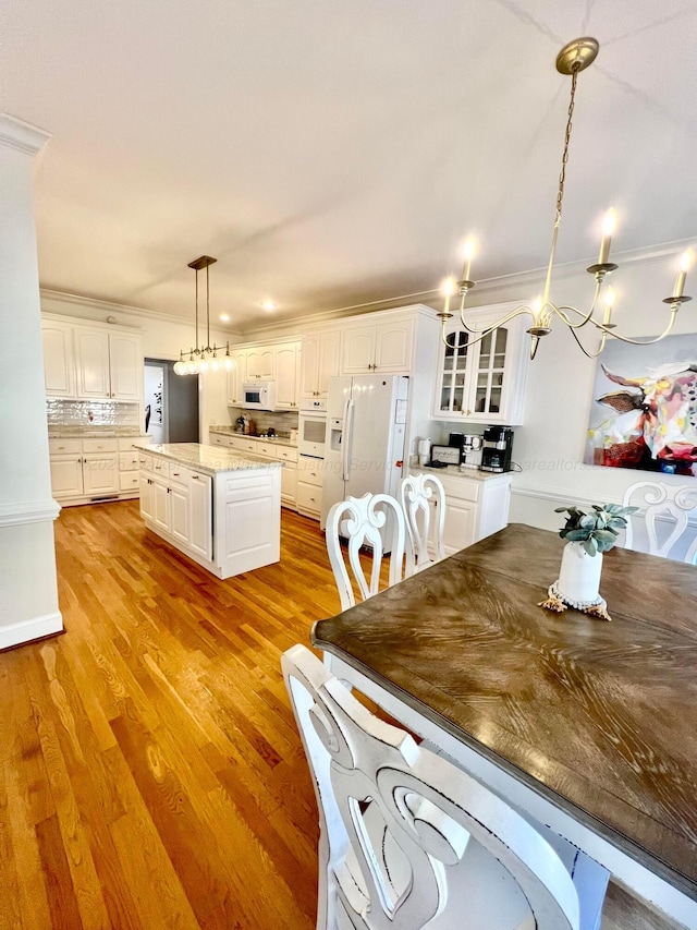 dining room featuring a chandelier, ornamental molding, and light wood-type flooring