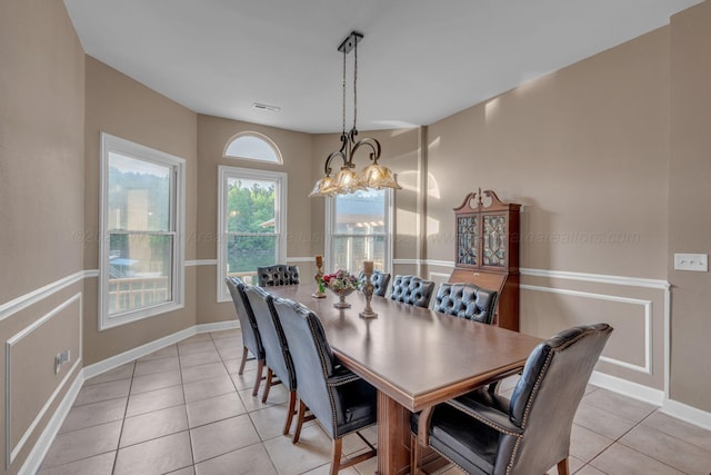dining area with visible vents, baseboards, a notable chandelier, and light tile patterned flooring