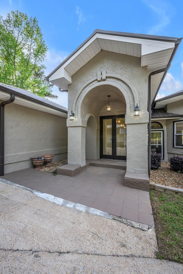 entrance to property with french doors and stucco siding