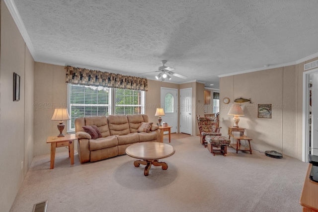 carpeted living area featuring crown molding, a ceiling fan, a textured ceiling, and visible vents