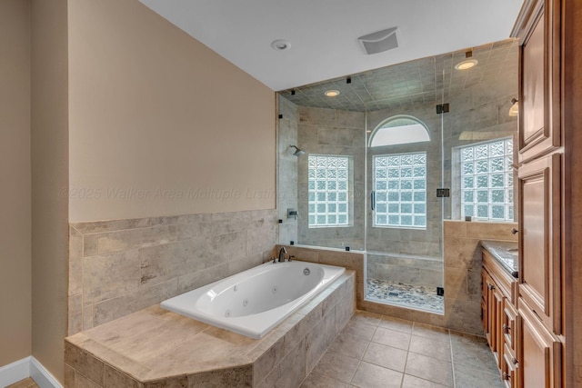 bathroom with vanity, tile patterned floors, a tub with jets, and a stall shower