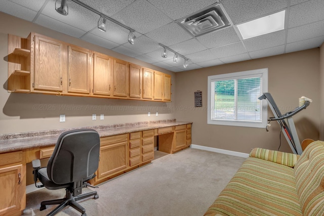 office space featuring built in study area, rail lighting, baseboards, and light colored carpet