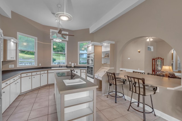kitchen featuring double oven, a sink, and light tile patterned floors