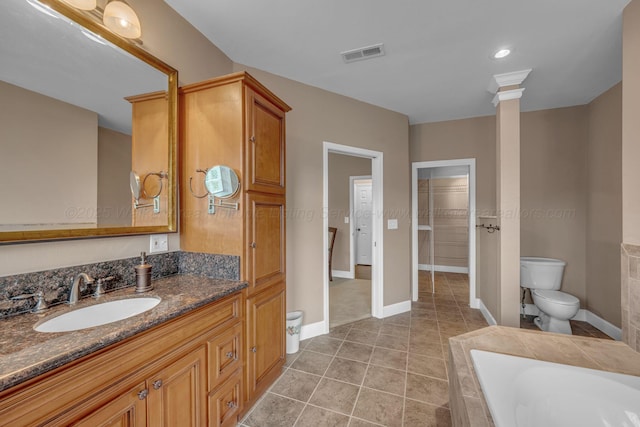 full bathroom featuring vanity, toilet, tiled tub, and visible vents