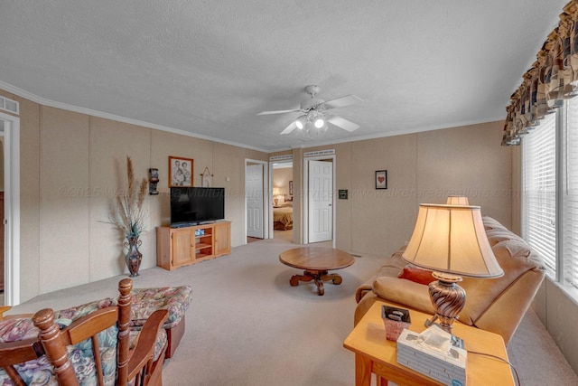 carpeted living room featuring crown molding, a ceiling fan, a textured ceiling, and visible vents