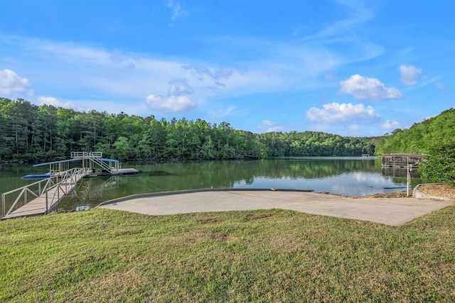 dock area featuring a lawn, a water view, and a view of trees