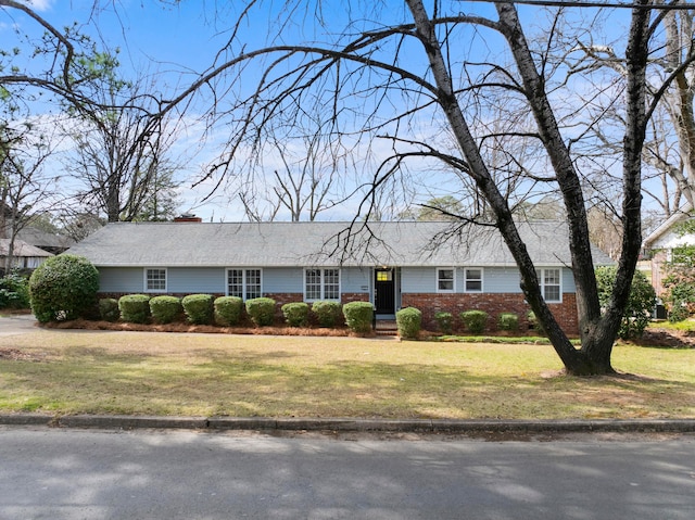 single story home with brick siding and a front lawn