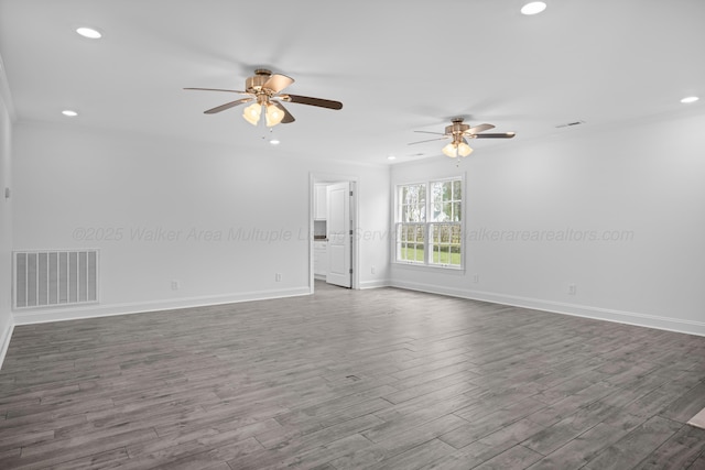 empty room with dark wood-style flooring, visible vents, recessed lighting, and a ceiling fan
