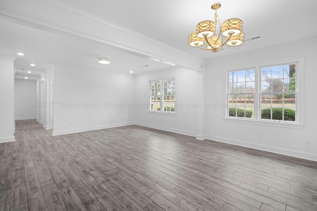 spare room featuring crown molding, dark wood-type flooring, and a chandelier
