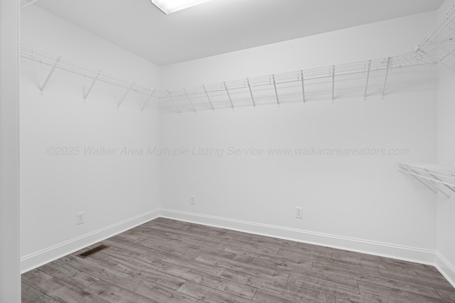 spacious closet with wood finished floors and visible vents