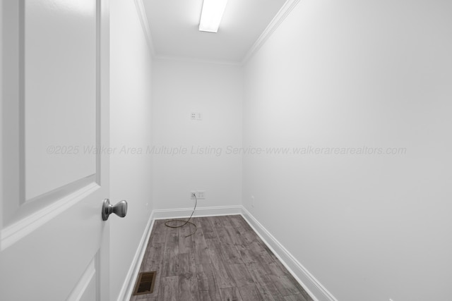 unfurnished room featuring dark wood finished floors, baseboards, visible vents, and crown molding