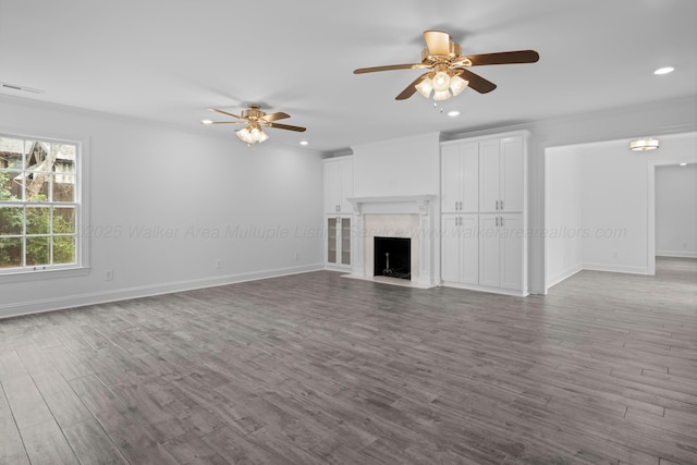 unfurnished living room featuring visible vents, wood finished floors, ceiling fan, and ornamental molding