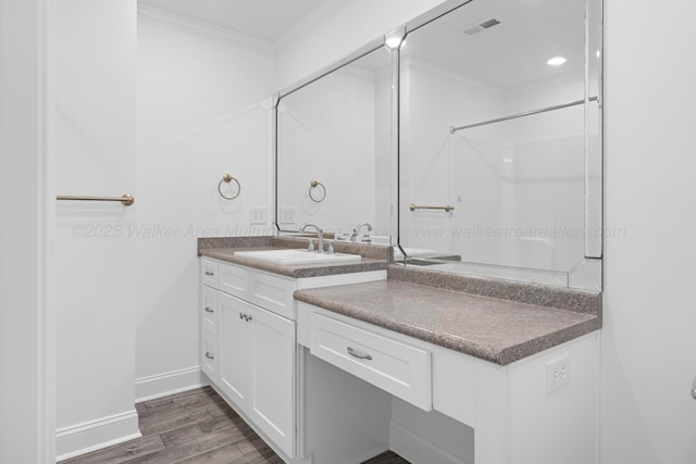 full bath with vanity, ornamental molding, baseboards, visible vents, and wood finished floors