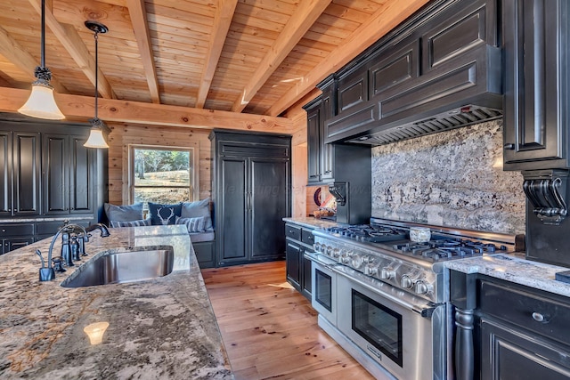 kitchen featuring light wood-style flooring, a sink, double oven range, beamed ceiling, and custom range hood