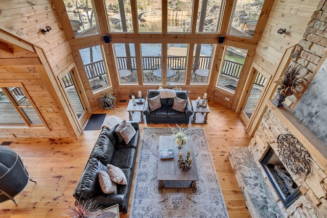 living room featuring hardwood / wood-style flooring, wood walls, and a high ceiling