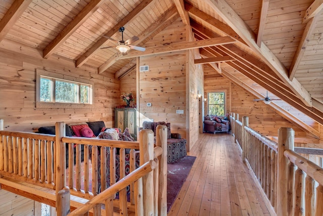 additional living space featuring wooden walls, lofted ceiling with beams, wood ceiling, and ceiling fan