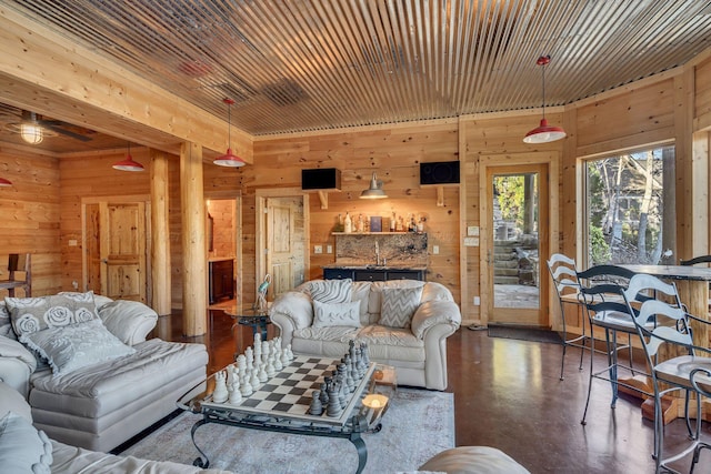 living room featuring wooden walls and finished concrete floors