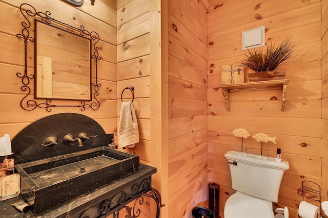 bathroom featuring wooden walls and toilet