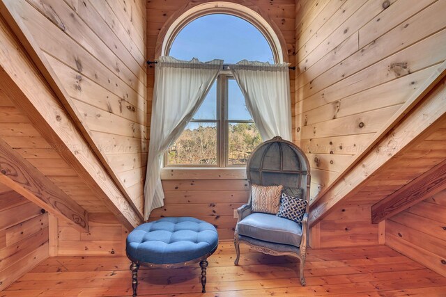 sitting room featuring wood-type flooring and wood walls