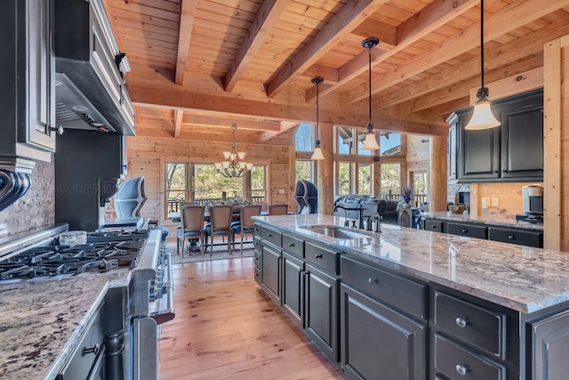 kitchen with wooden ceiling, a sink, light wood-style floors, beam ceiling, and stainless steel stove
