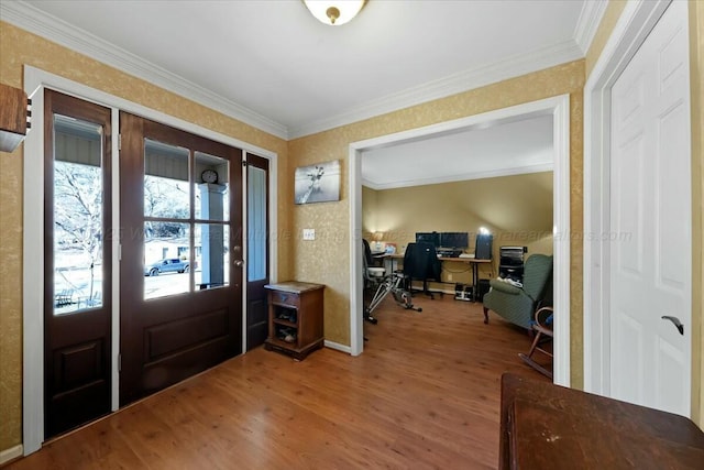 foyer with wood finished floors and crown molding