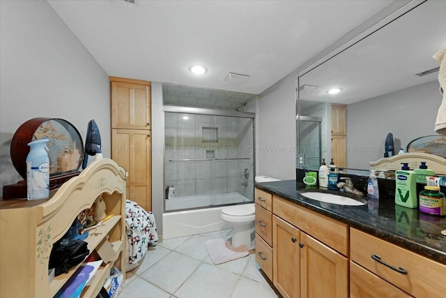 full bath with tile patterned floors, enclosed tub / shower combo, toilet, and vanity