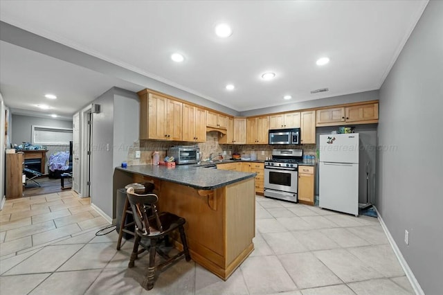 kitchen featuring tasteful backsplash, dark countertops, visible vents, a peninsula, and appliances with stainless steel finishes