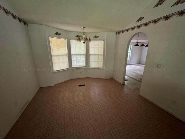 151 Bassmen Dr, Parrish, AL 35580 - carpeted empty room featuring a chandelier, arched walkways, and baseboards