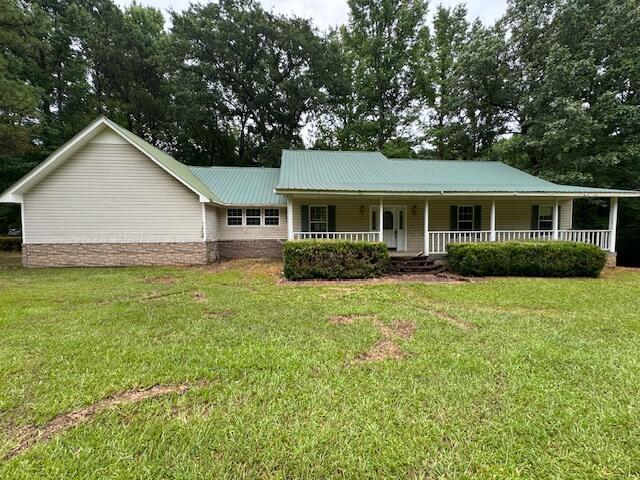 151 Bassmen Dr, Parrish, AL 35580 - view of front facade with a porch, a front yard, and metal roof