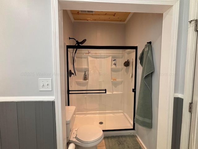 bathroom with toilet, visible vents, ornamental molding, and a shower stall