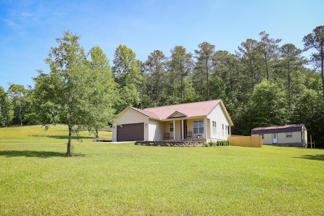 view of front of house with a porch, a garage, a front yard, and metal roof
