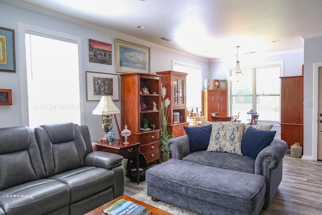 living room featuring visible vents, ornamental molding, and wood finished floors