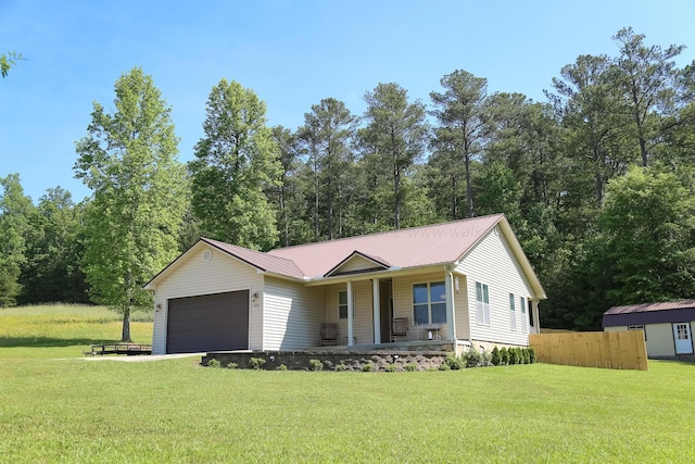 ranch-style house with an attached garage, fence, a front yard, metal roof, and a porch