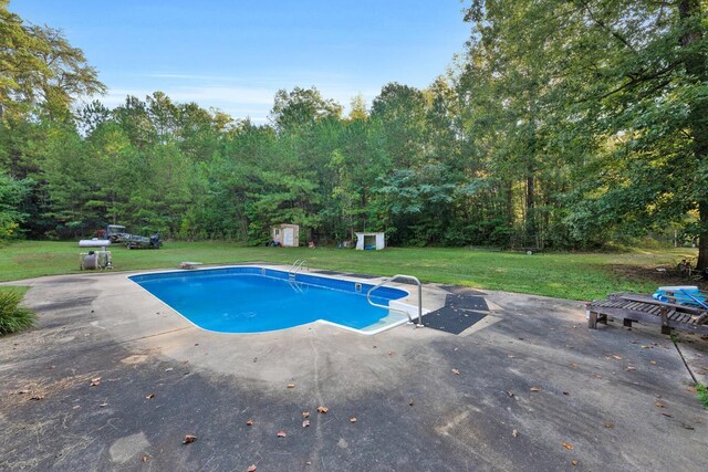 view of swimming pool featuring a patio area, a diving board, a yard, and a storage unit