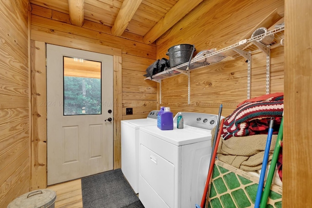 clothes washing area with washer and dryer, wood-type flooring, wooden walls, and wood ceiling