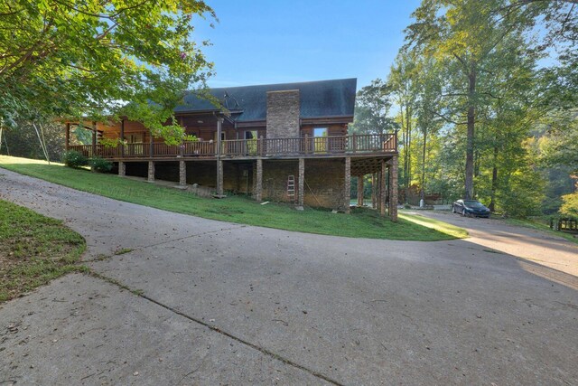 log-style house with a deck and a front lawn