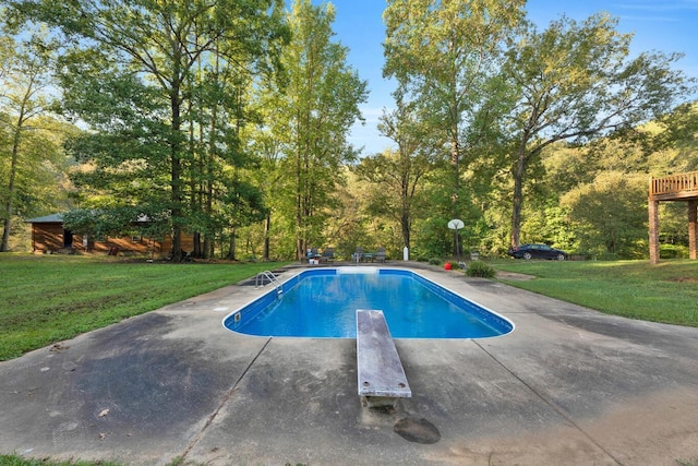 view of swimming pool with a lawn and a diving board