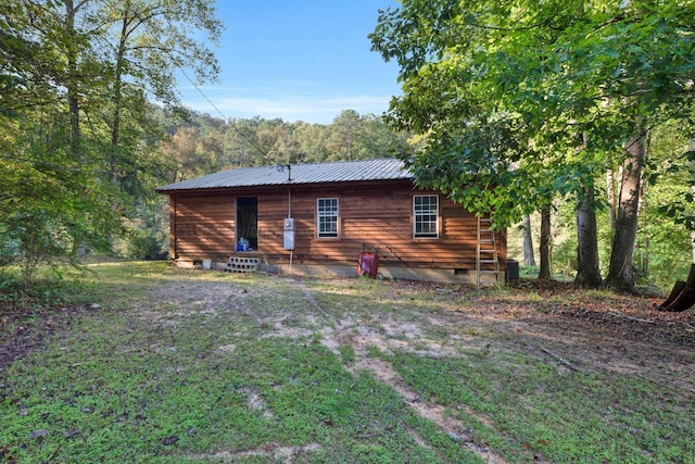 back of property featuring a lawn