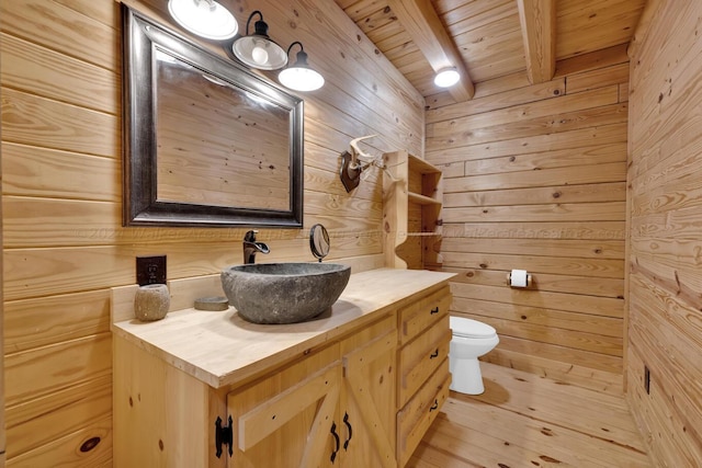 bathroom featuring wood ceiling, vanity, wooden walls, wood-type flooring, and beamed ceiling