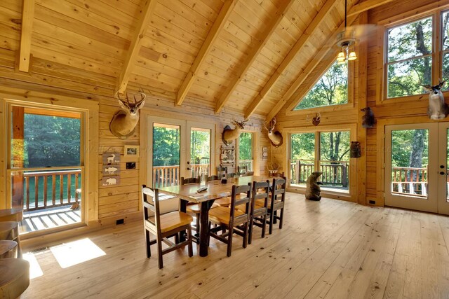 dining area featuring a wealth of natural light, french doors, wooden walls, wood ceiling, and light wood-type flooring