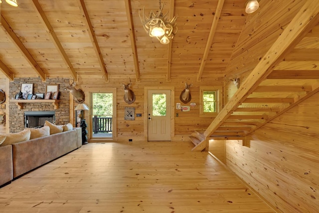 unfurnished living room with vaulted ceiling with beams, wood walls, a fireplace, and hardwood / wood-style flooring