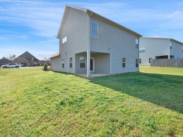 back of house with fence, a yard, and a patio