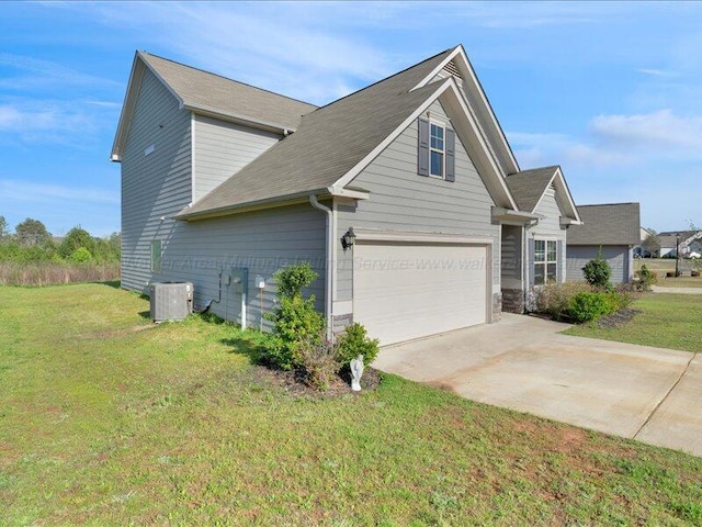 view of side of property with a garage, driveway, central AC, and a yard