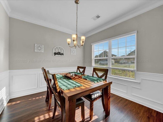 dining space with dark wood-style flooring, visible vents, an inviting chandelier, and wainscoting